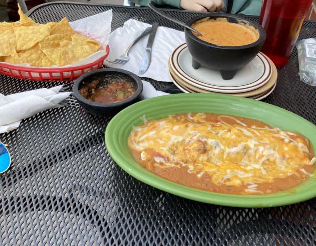 smothered burrito, chips and salsa, and queso on a table