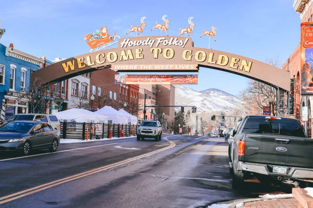 A large sign over a street that says "Howdy Folks Welcome to Golden". 