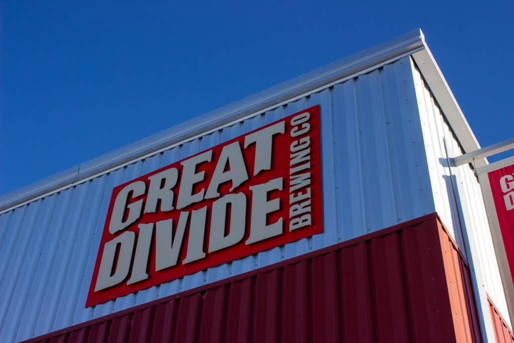 Red sign on the side of a building that says Great Divide Brewing Co.